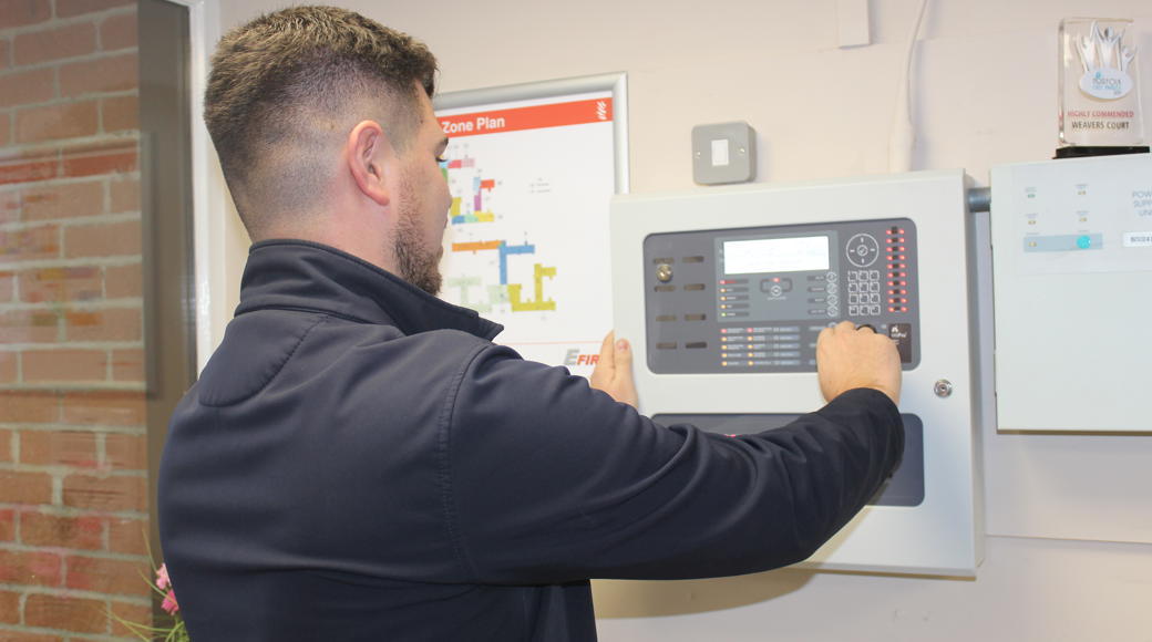 Staff Member Inspecting A Fire Panel In One Of Our Schemes