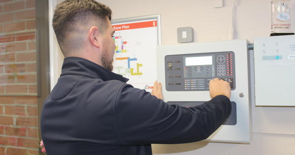 Staff Member Inspecting A Fire Panel In One Of Our Schemes