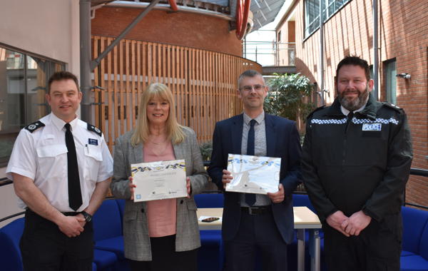 Saffron And R G Carter Staff Holding Award Next To Policemen