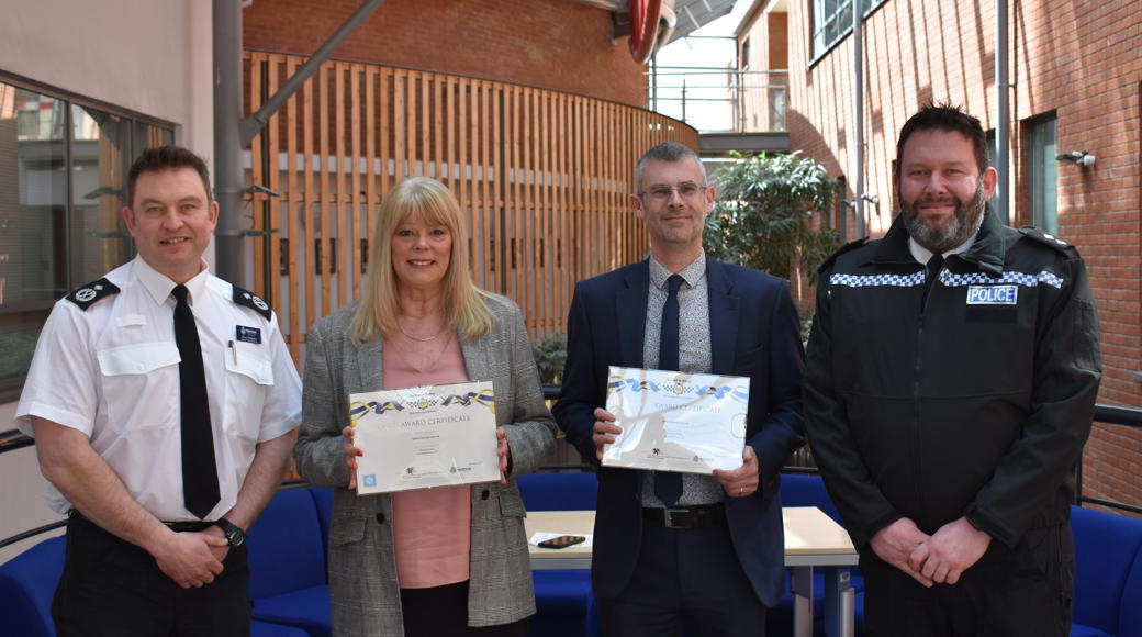 Saffron And R G Carter Staff Holding Award Next To Policemen
