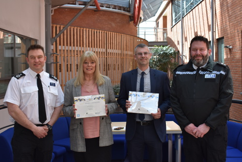 Saffron And R G Carter Staff Holding Award Next To Policemen