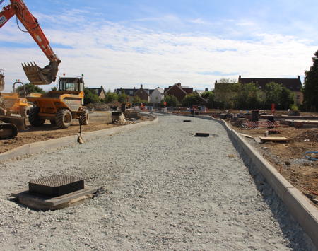 Construction Site With Yellow Digger And Houses In Background