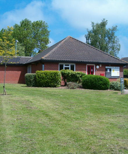 Red Brick One Story Building With Red Door On Playingfield