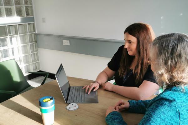 Staff And Tenant Group Member Sitting At A Desk