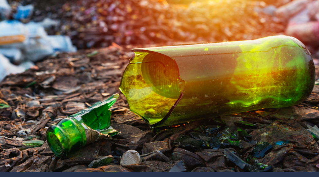 Broken Green Bottle On Floor With Rubbish In The Background
