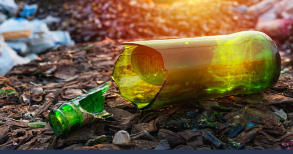 Broken Green Bottle On Floor With Rubbish In The Background