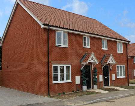 Two Orange Brick Homes With White Doors
