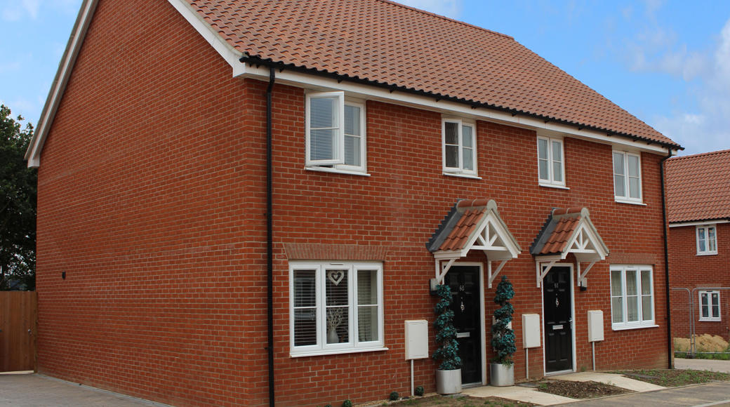 Two Orange Brick Homes With White Doors
