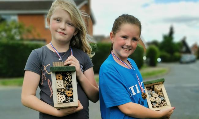 Two Children Holding Bug Hotels