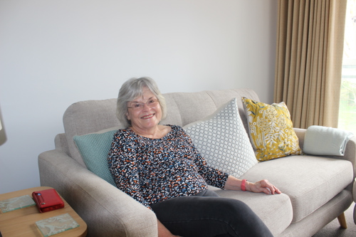 Tenant Of Swallowtail Place Sitting On Sofa Smiling