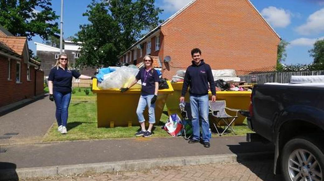 3 Saffron Staff Members Standing In Front Of A Yellow Skip On A Sunny Day