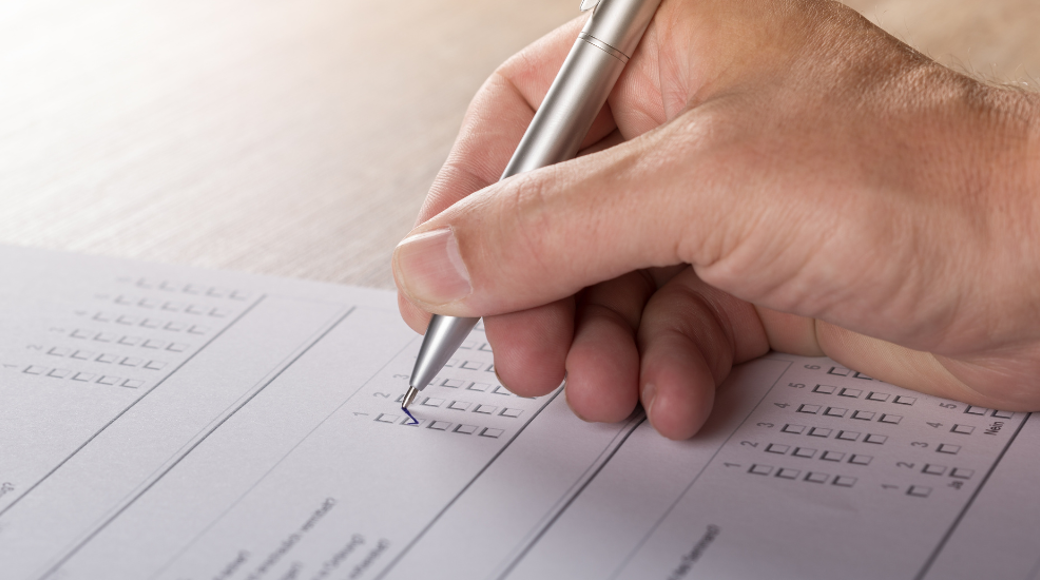 Hand Holding Pen Filling Out Paper Application Form