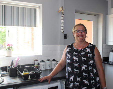 Tenant Standing In Kitchen Smiling