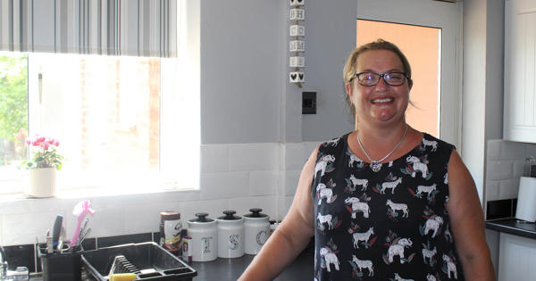 Tenant Standing In Kitchen Smiling