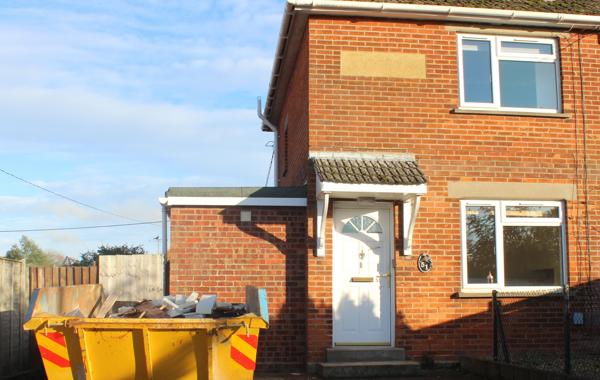 House With Yellow Skip Outside