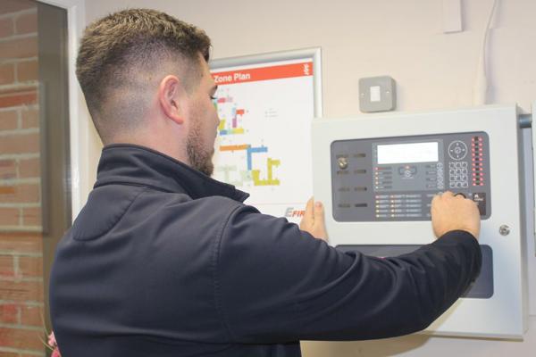 Staff Member Inspecting A Fire Panel In One Of Our Schemes