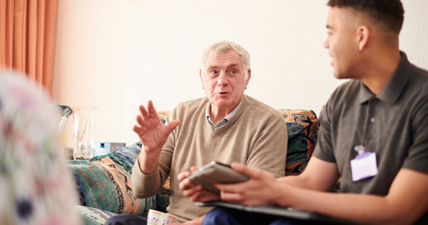 Two People Sitting On A Sofa Having A Conversation