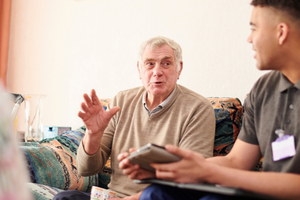 Two People Sitting On A Sofa Having A Conversation