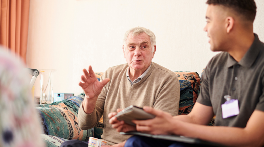 Two People Sitting On A Sofa Having A Conversation